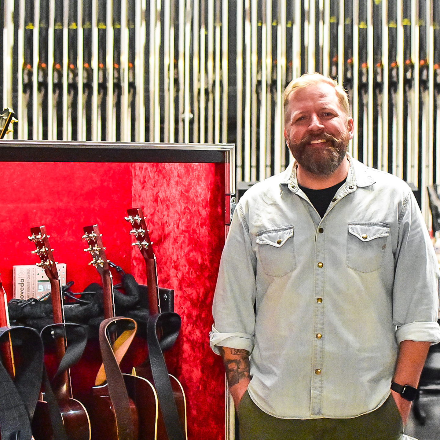 Photo of Michael in front of guitars